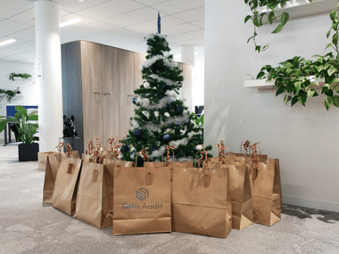 Entreprise qui fête noël avec un sapin et des cadeaux